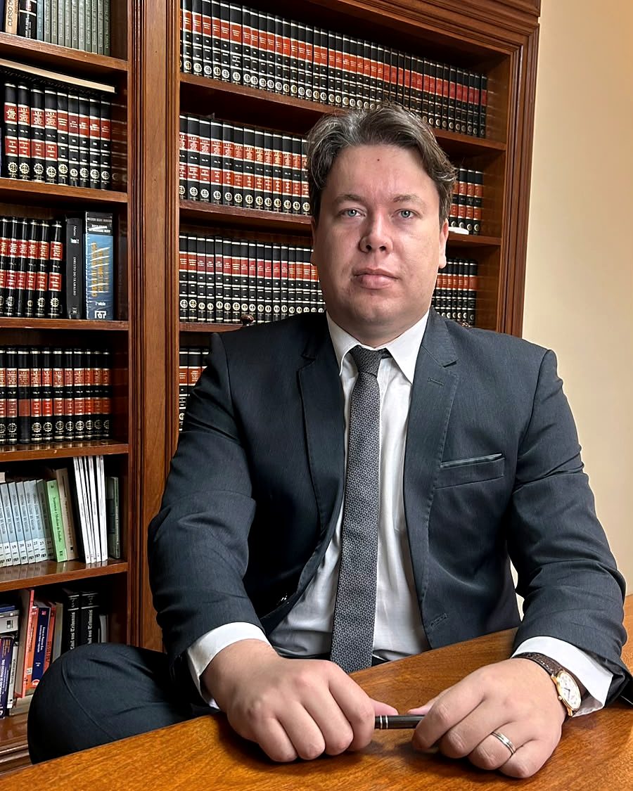 Dr. Lucas Ferreira Faleiros analisando documentos à mesa